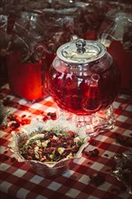 Herbal tea in glass teapot on table