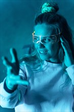 Woman with futuristic glasses gesturing against a blue background