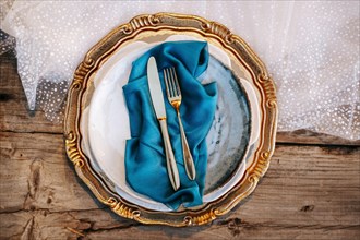 Golden and blue elegant table set on wedding dress