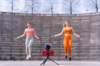 Two young fitness woman in a city park