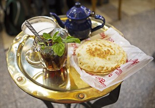 Traditional mint tea and flatbread on a golden tray