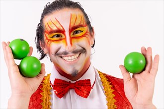 Portrait of smiling juggler juggling green balls isolated on white background