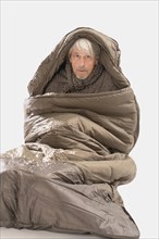 Elderly gentleman freezing in sleeping bag