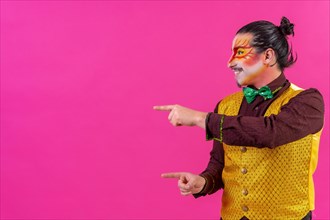 Clown with white facial makeup showing empty space from pink background