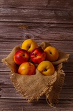 Group of fresh nectarines on a raffia cloth with a dark wood background