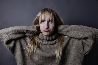 Young woman with long blond hair and a woollen jumper