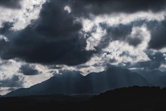 Dramatic sky with huge dark clouds over rugged mountain silhouettes in Spain