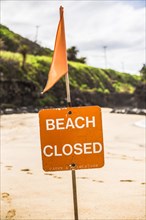A Beach closed sign at the beach in the north shore of Oahu