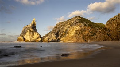 Sunset on sandy beach with rocks