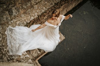 Dreamy portraits of a beautiful bride on stone riverbank