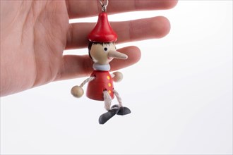 Wooden pinocchio doll with his long nose on a white background