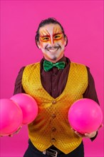Portrait of clown with white facial makeup on a pink background