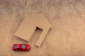 Paper house and a model car on a canvas background
