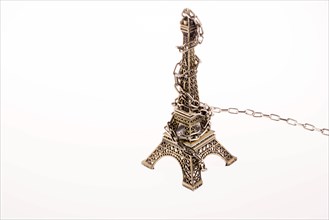 Little model Eiffel Tower in chains on a white background