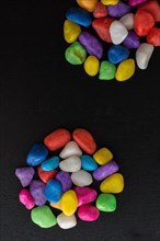 Pile of little colorful pebbles on black background