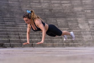 Caucasian young woman doing fitness in a city park