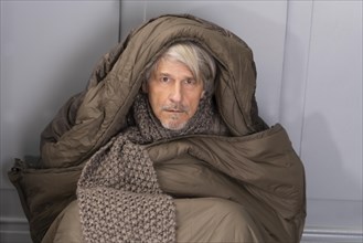 Elderly gentleman freezing in sleeping bag