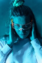 Woman with futuristic glasses gesturing against a blue background