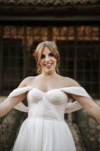 Beautiful bride portrait standing on wooden bridge with stone house behind