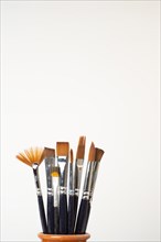 Earthenware jar with brushes isolated on a white background