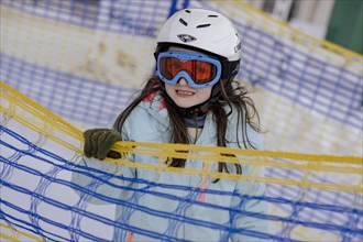 Girl skiing with helmet and ski goggles