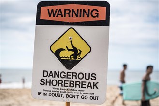 A dangerous shorebreak sign at the beach in the north shore of Oahu