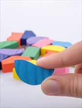 Colorful wooden pieces of a logic puzzle in hand