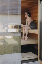 Woman sitting in Finnish sauna