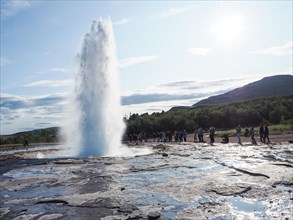 Tourists watching a geyser erupt