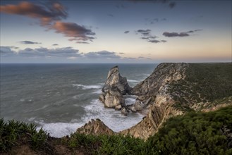 Sunset on the cliff with rocks in the sea