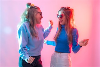 Two young blonde caucasian women dancing in nightclub