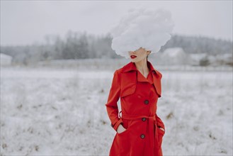 Woman in red coat with cloud on her head in the snow