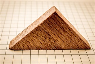 Piece of wood in the shpae of a triangle on paper