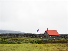 Icelandic flag in front of hut in the highlands of Iceland