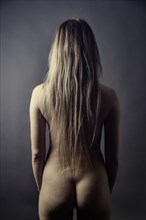 Nude young woman with long blond hair