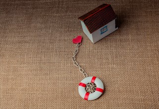 Model house and a life preserver with a heart on a chain
