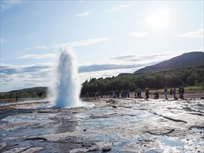 Tourists watching a geyser erupt