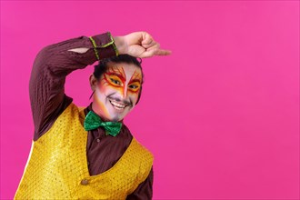 Clown with white facial makeup showing an empty space from the pink background