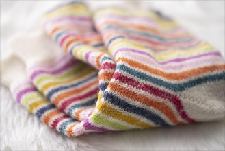 Colourful striped wool socks on faux fur