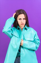 Close up portrait of a young caucasian woman in blue trench coat isolated on purple background