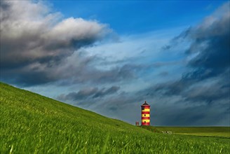 Pilsum lighthouse on the dyke near Greetsiel in the Krummhoern region on the East Frisian North Sea coast