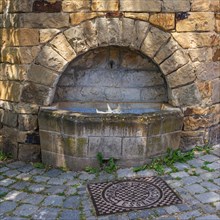 Old historical empty well in a stone wall