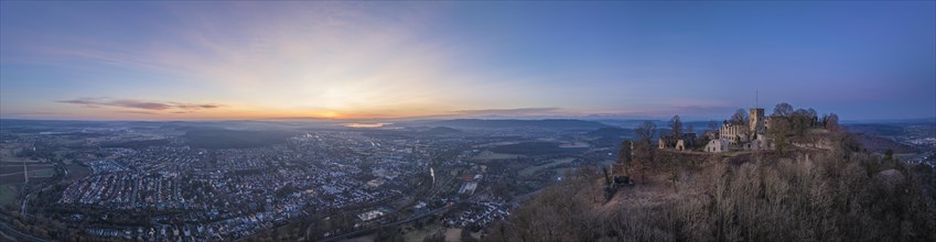 Panorama of the Hohentwiel castle ruins with the town of Singen am Hohentwiel in front of sunrise