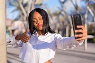 Young african woman in white clothes in the city at sunset
