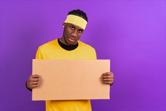 Black ethnic man in yellow clothes on a purple background