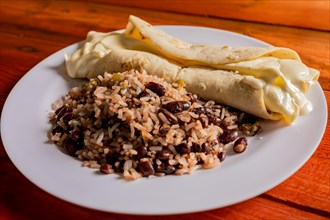 Traditional gallo pinto with Quesillo served on wooden table. Nicaraguan gallopinto with quesillo on the table. typical nicaraguan foods
