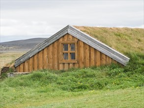 Traditional wooden peat house with grass on the roof