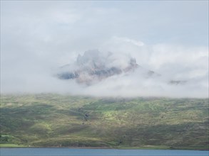 Fog drifts over mountainside