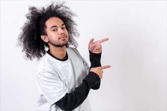 Pointing to the right at a copy paste space. Young man with afro hair on white background
