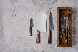 Used forged tools of butcher on stone background